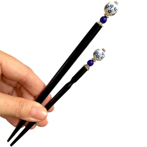 The standard and large size of the Nora Tidal Hair Stick made from blue flowered white ceramic beads.