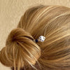 A woman wears a Nora Hair Stick in her hair bun.