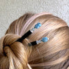 A woman wearing a pair of our Skye Hair Sticks made from aquamarine nuggets.
