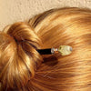 A blonde woman wears a messy hair bun using the Vera Tidal Hair Stick made of yellow green Prehnite Stone beads.
