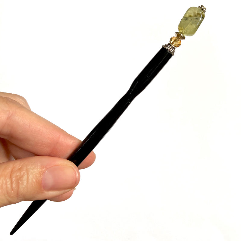 A close up view of the Vera Tidal Hair Stick made of yellow green Prehnite Stone beads