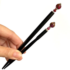 The standard and large sizes of the Wynn Tidal Hair Stick made from red magenta pyrite quartz