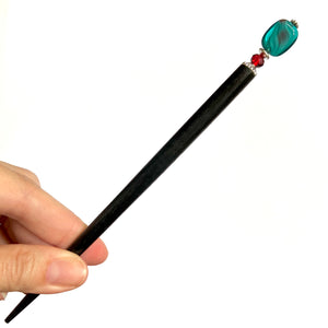 The large size of the Zara Hair Stick made from teal blue and red swirl Czech glass beads.