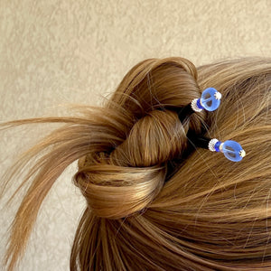 A woman wears two of our Sydney Hair Sticks made from sapphire blue Czech glass beads.