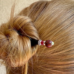 A woman wears a Wynn Tidal Hair Stick in her hair bun. 