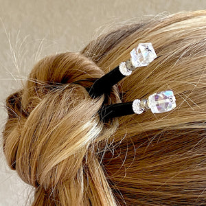 A woman wears two of the Nicole Tidal Hair Stick made with an iridescent clear square bead and crystal accent. 